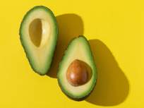 a halved avocado on a yellow background